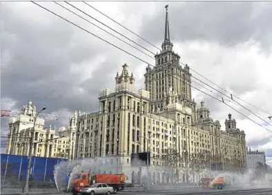  ?? ULF MAUDER / DPA ?? Camiones de limpieza desinfecta­n las calles de Moscú frente al Hotel Ukraine.