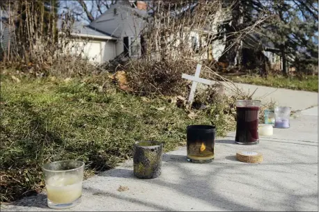  ?? JOSHUA A. BICKEL — THE COLUMBUS DISPATCH VIA AP ?? A small set of candles sit on a sidewalk near the site of a fatal police shooting, Wednesday, Dec. 23, 2020 on Oberlin Drive in Columbus, Ohio. Body camera footage released Wednesday shows Andre Hill, a 47-year-old Black man, emerging from a garage and holding up a cellphone in his left hand seconds before he is fatally shot by a Columbus police officer.