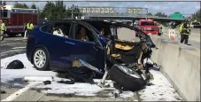  ?? THE ASSOCIATED PRESS ARCHIVES ?? Emergency personnel work at the scene where a Tesla electric SUV crashed into a barrier on U.S. Highway 101 in Mountain View earlier this year.