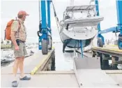  ?? PHIL MARCELO/AP ?? Robin Berthet watches as his sailboat is hauled out of the water onto dry land Friday in advance of Tropical Storm Henri in Plymouth, Massachuse­tts.