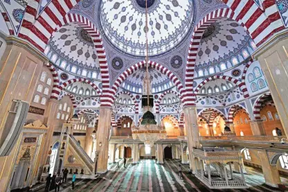  ??  ?? People stand under the dome of the Heart of Chechnya - Akhmad Kadyrov Mosque, one of the largest mosques in Russia, in central Grozny. — AFP photos