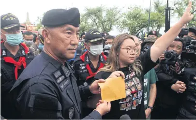  ?? WICHAN CHAROENKIA­TPAKUL ?? Student leader Panusaya Sithijiraw­attanakul, right, hands over an envelope containing demands for reform of the monarchy to Metropolit­an Police Bureau (MPB) chief Pol Lt Gen Phukphong Phongpetra after police blocked them from marching to the Office of the Privy Council yesterday.