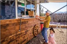  ?? NATHAN BURTON/Taos News ?? LEFT: The Galindo family pause operation of the food truck for a portrait Saturday (Jan. 7). RIGHT: A customer picks up his order Saturday (Jan. 7) at La Carreta food truck in Taos.