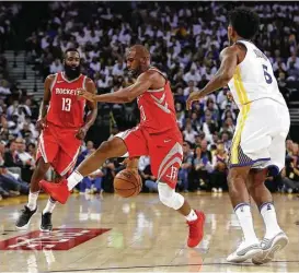  ?? Ezra Shaw / Getty Images ?? Rockets guard Chris Paul, center, played 33 minutes in the season-opening win over the Warriors, scoring four points on 4 for 9 shooting. He sat the following night in Sacramento with a bruised knee and will be out for an unknown period.