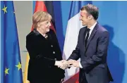  ?? [AP PHOTO] ?? German Chancellor Angela Merkel, left, and France’s President Emmanuel Macron, right, shake hands after a joint statement prior to a meeting Sunday at the chanceller­y in Berlin, Germany.