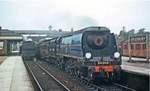  ?? H.n. James/coLoUR RaiL ?? A microcosm of British Railways in one photograph, as ex-Southern Railway ‘West Country’ No. 34006 Bude, coupled to an ex-LMS Stanier tender and the LNER dynamomete­r car, rattles through Aylesbury – passing an unidentifi­ed ex-GWR tank engine paused on...