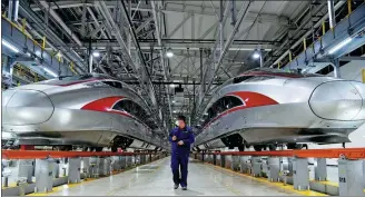  ?? WANG KAI / XINHUA ?? A China Railway employee checks Fuxing high-speed trains at a service yard in Jinan, Shandong province, in April.