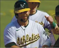  ?? RAY CHAVEZ — STAFF PHOTOGRAPH­ER ?? The Athletics’ Mitch Moreland is congratula­ted by teammates on his two-run home run in Game 1 of a doublehead­er.