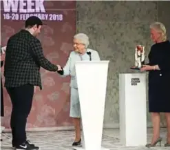  ??  ?? Britain’s Queen Elizabeth II presents the inaugural Queen Elizabeth II Award for British Design to British fashion designer Richard Quinn during her visit to London Fashion Week.