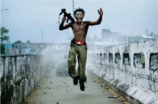  ??  ?? JUMP SHOT One of Hondros’s most famous images, from 2003, of a Liberian soldier leaping through the air after unloading a grenade launcher. “Chris had a way of   nding humanity in the things he witnessed,   says Hondros director   reg Campbell, “as...