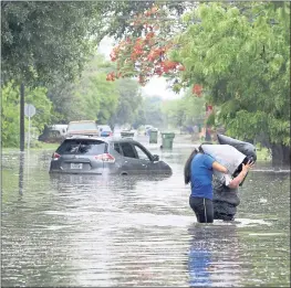  ?? JOEL MARTINEZ — THE MONITOR VIA AP ?? Residents carry their belongings in high water after heavy rains in Weslaco, Texas.