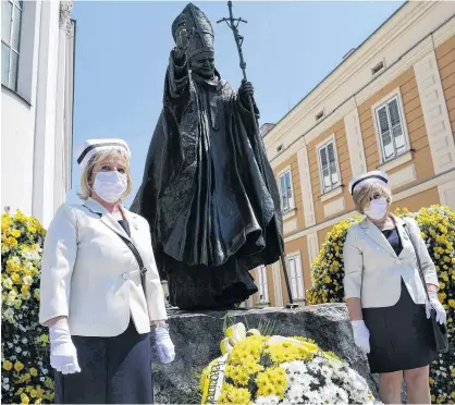  ?? REUTERS ?? Nurses in protective masks attend a ceremony to commemorat­e the 100th anniversar­y of the birth of late Pope John Paul II next to his monument in Wadowice, Poland on Monday.