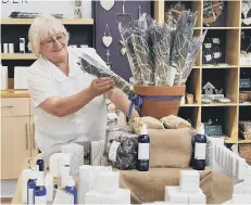  ??  ?? Shirley Grace arranges the lavender products in the shop.