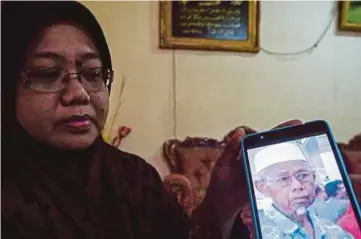  ??  ?? AZIZAH menunjukka­n gambar ayahnya, Mohd Rapini.