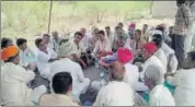  ?? HT PHOTO ?? Villagers sit on a dharna outside a liquor shop in Mithdau village in Barmer.