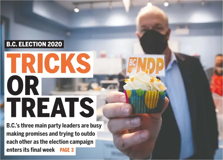  ?? — THE CANADIAN PRESS ?? NDP Leader John Horgan holds a party-branded cupcake during a campaign stop at a cupcake shop, in Pitt Meadows on Friday.