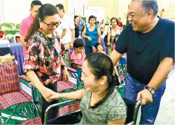  ?? (SUN.STAR FOTO/ALEX BADAYOS) ?? SERVICE. Gweyn Garcia, a person with disability in Bantayan Island, is assisted by Gov. Hilario Davide III and greeted by Vice Gov. Agnes Magpale after she got a wheelchair from the Provincial Government.