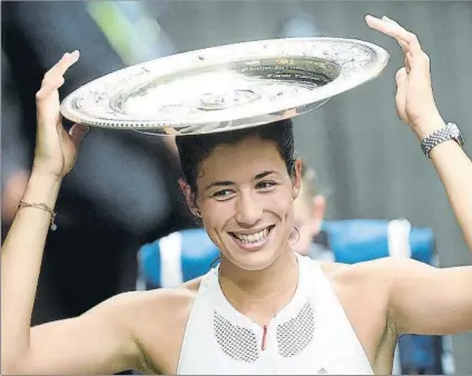  ?? FOTO: EFE ?? Garbiñe Muguruza, bromeando con el famoso ‘plato’ de campeona de Wimbledon. Tuvo muy claro que el tenis era lo suyo desde niña