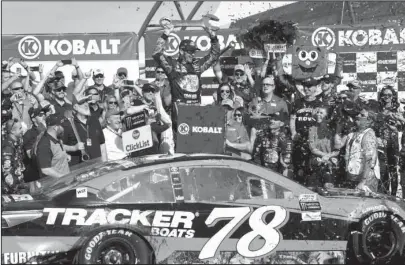  ?? The Associated Press ?? CELEBRATIN­G THE WIN: Martin Truex Jr. celebrates after winning a NASCAR Cup Series race Sunday in Las Vegas. Truex Jr. was able to avoid a last-lap wreck while winning all three segments of the race.