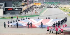  ?? REUTERS ?? A Union Jack flag is carried out on to the track at Silverston­e.