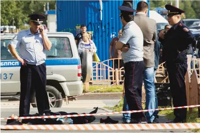  ??  ?? Police officers stand by the body of a man who was killed after an alleged stabbing attack in the Siberian city of Surgut, Russia, Saturday. (AP)