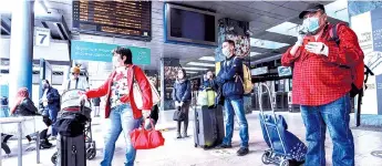  ?? — AFP photo ?? Travellers wait for a train at the Cardona railway station in Milan, as Italy starts to ease its lockdown.