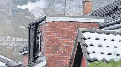  ??  ?? ●» A upstairs window damaged by fire at the house on Hulley Road in Hurdsfield