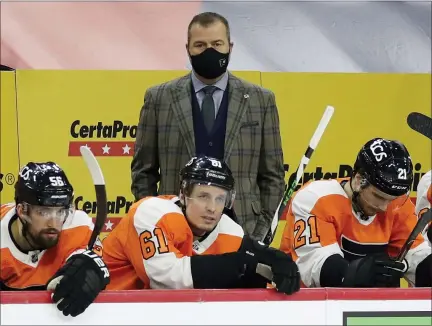  ?? ASSOCIATED PRESS FILE ?? Flyers coach Alain Vigneault watches his team play the Boston Bruins with Flyers defensemen Erik Gustafsson, Justin Braun and center Scott Laughton on the bench on Feb. 5.