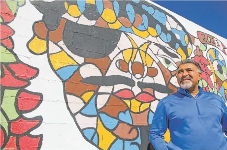  ?? GABRIELA CAMPOS/THE NEW MEXICAN ?? Al Hurricane Jr. stands in front of a mural of his father, Al Hurricane, across the street from Barelas Coffee House in Albuquerqu­e. The mural was painted in 2013. Hurricane died Sunday after a battle with cancer.