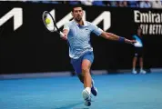  ?? Louise Delmotte/Associated Press ?? Novak Djokovic plays a forehand return to Taylor Fritz during the quarterfin­als at the Australian Open on Tuesday.
