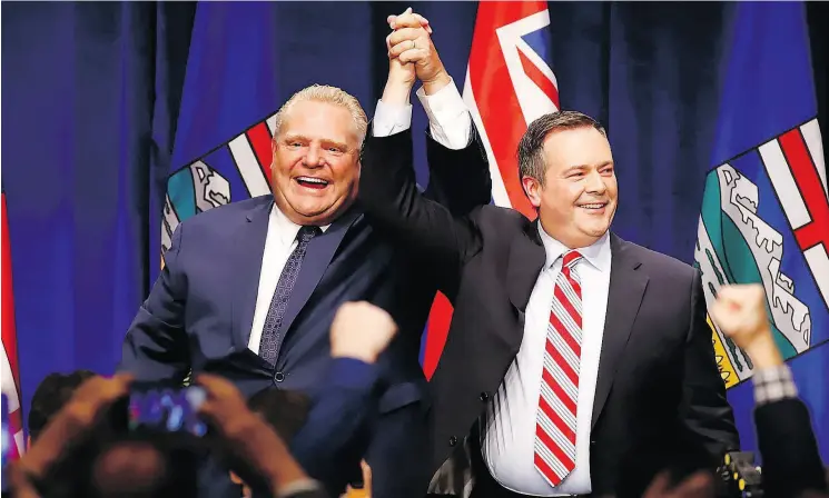  ?? JEFF MCINTOSH / THE CANADIAN PRESS FILES ?? Ontario Premier Doug Ford, left, and Alberta United Conservati­ve Party Leader Jason Kenney cheer with supporters at an anti-carbon tax rally in Calgary in October.