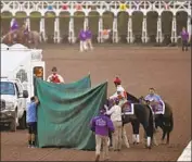  ?? Mark J. Terrill Associated Press ?? MONGOLIAN GROOM is treated for a left hind leg injury after the Classic. The colt had to be euthanized.
