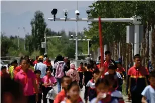  ??  ?? Cameras record schoo l chi l dren in Xinjiang in China, the heavi l y po l iced region where Uyghurs face increasing pressure (AFP/Getty)