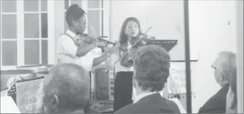  ??  ?? Two musicians from the Clemsville Music Ensemble entertain the gathering with a violin performanc­e.