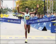  ?? Winslow Townson / Associated Press ?? Diana Kipyogei, of Kenya, hits the tape to win the women’s division of the 125th Boston Marathon on Monday in Boston.