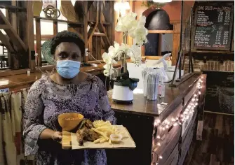  ?? RYAN KNELLER/THE MORNING CALL ?? Braai Hut owner Sibu Mafundikwa poses with flame-grilled peri peri chicken, fries and chakalaka beans at the newly opened Zimbabwean restaurant at 216 E. Broad St. in Bethlehem.