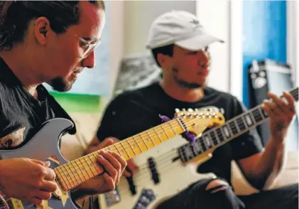  ?? STAFF PHOTOS BY C.B. SCHMELTER ?? Tyler Martelli, left, and Jared White play guitar and bass while jamming in the studio at The Flock.