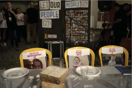  ?? MAYA ALLERUZZO — THE ASSOCIATED PRESS ?? Chairs for the Bibas family, hostages held in Gaza at a Passover seder table set on Thursday at the communal dining hall at Kibbutz Nir Oz in southern Israel, where a quarter of all residents were killed or captured by Hamas on Oct. 7, 2023.