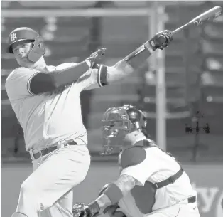  ?? MICHAEL DWYER/AP ?? The Yankees’ Gary Sanchez follows through on a solo home run in front of Red Sox catcher Christian Vazquez during the ninth inning Friday in Boston.