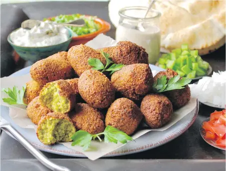  ??  ?? Flavourful homemade falafel accompanie­d by pita, raw vegetables and Middle Eastern-style sauces.