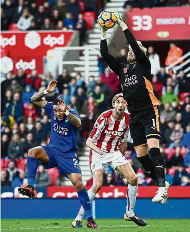  ??  ?? What a save!: Leicester goalkeeper Kasper Schmeichel catching the ball ahead of Stokes’ Peter Crouch (centre) in the English Premier League match at the Bet365 Stadium yesterday. The match ended 2-2.