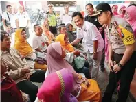  ?? CHUSNUL CAHYADI/JAWA POS ?? PASIEN LANJUT USIA: Wakil Bupati Moh. Qosim dan Kapolres Gresik AKBP Wahyu S. Bintoro berdialog dengan masyarakat yang hendak menjalani operasi katarak kemarin.