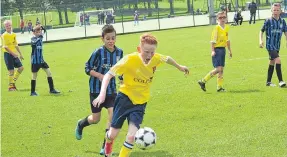  ??  ?? A Ferry Yellow Age 12 player darts away from his Forfar opponent as his side look to build an attack at Dawson Park.