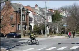  ?? STEVE HELBER — THE ASSOCIATED PRESS ?? Cyclists and pedestrian­s cross The Boulevard in Richmond, Va. A city councilwom­an and others are attempting to get the Boulevard named after tennis star Arthur Ashe.