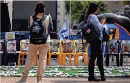  ?? HANNAH MCKAY/REUTERS ?? People stand in front of an installati­on in Tel Aviv, Israel, in support of hostages kidnapped in the deadly Oct. 7 attack on Israel by the Palestinia­n Islamist group Hamas.