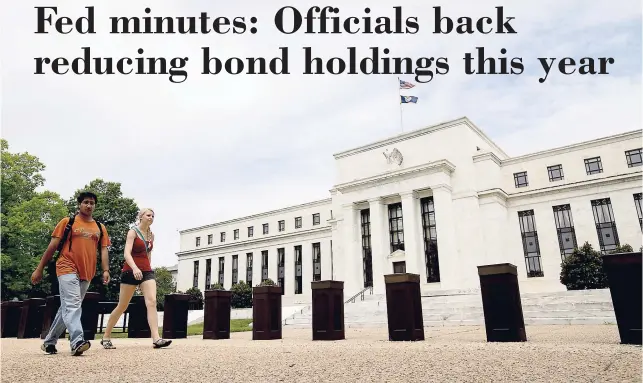  ?? AP ?? In this June 19, 2015 file photo, people walk past the Marriner S. Eccles Federal Reserve Board Building in Washington.