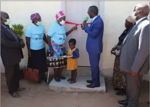  ?? ?? Homeowner… Urban and Rural Developmen­t minister Erastus Uutoni official hands over the house to Maria Mutelo at Kongola in the presence of Zambezi governor Lawrence Sampofu and other government officials.
