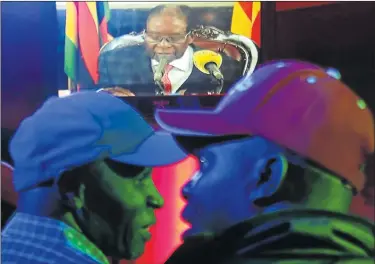  ?? Picture: REUTERS/PHILIMON BULAWAYO ?? WHAT’S HAPPENING?: People watch at a bar in Harare, Zimbabwe, as President Robert Mugabe addresses the nation on television