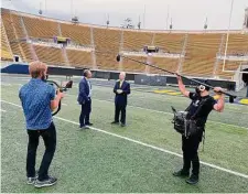  ?? ESPN ?? Jeremy Schaap (second from left) interviews Cal broadcaste­r Joe Starkey for the documentar­y “The Band is on the Field.”