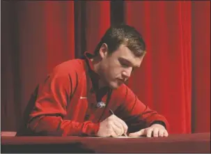  ?? The Sentinel-Record/Richard Rasmussen ?? SIGNING ON: Lake Hamilton High School Senior Ian Bishop signs a certificat­e of intent to attend the University of Arkansas during an academic signing day Monday in the Lake Hamilton High School Auditorium. This was the culminatin­g event of the...